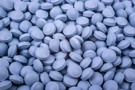 蓝色的药丸放在桌子上照片