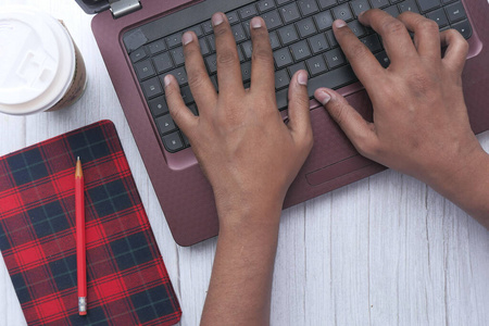 top view of man hand use laptop and tea cup on color background 