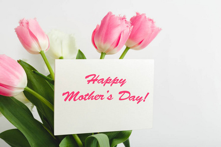 白色背景的鲜花花束礼品卡上的母亲节快乐文字。给妈妈的贺卡。送花，女性鲜花祝贺卡。粉红色郁金香贺卡。