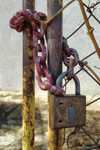 一把生锈的旧挂锁，门上挂着一条链条
