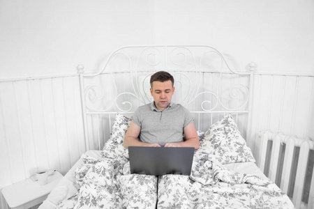 male freelancer working from home in the bedroom 