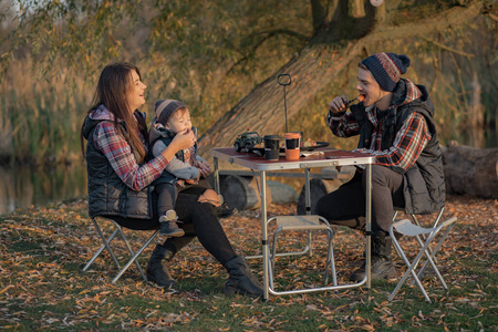 可爱的一家人坐在森林里野餐图片