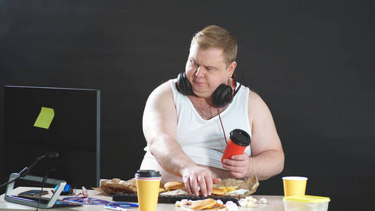 胖胖的程序员在家里远程操作电脑,一个人一边工作一边吃饭,与世隔绝的