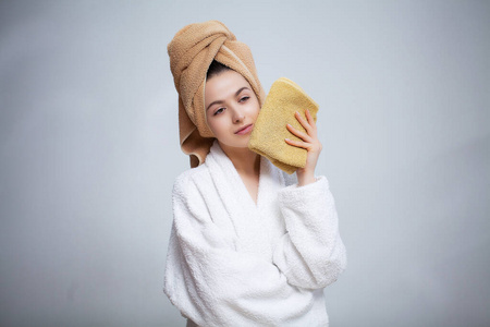 宁静的卫生穿白大褂的漂亮女孩洗完澡后用毛巾擦脸照片