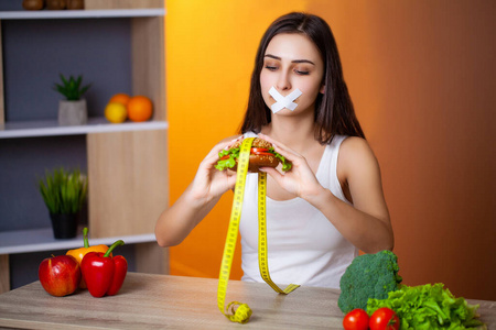 女人想吃汉堡却卡在了斯科舍姆口中，这是节食的概念。