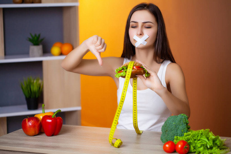 女人想吃汉堡却卡在了斯科舍姆口中，这是节食的概念。