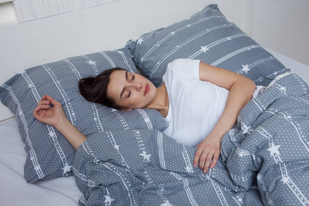 年轻美女床上睡觉晚上健康睡在床上,漂亮的年轻黑发女人睡觉照片