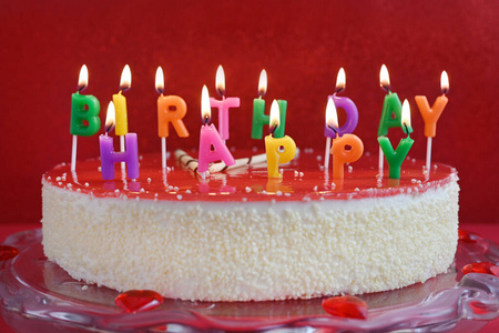 生日蛋糕，在红色的派对背景上插上蜡烛