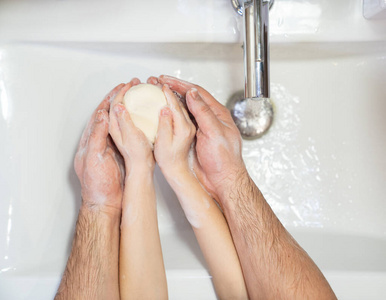 prevention. dad with daughter washing hands. 