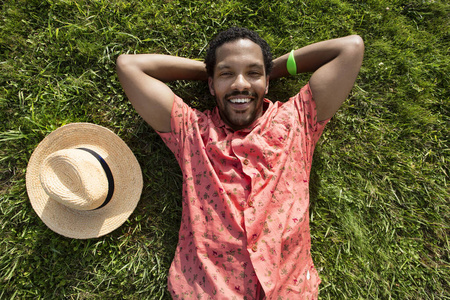 黑人男性,很高兴能在绿草丛生的草地上度过余生.照片