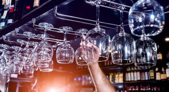 Wine and martini glasses in shelf above a bar rack in restaurant