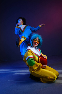 两个小丑一男一女穿着80年代风格的鲜艳运动服化妆。