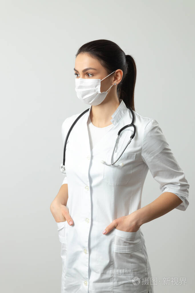 严肃的医生在灯光背景下摆姿势照相