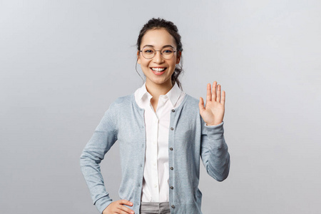 友好热情的亚洲女性戴着眼镜,挥手打招呼,打招呼手势,学生们在app在线