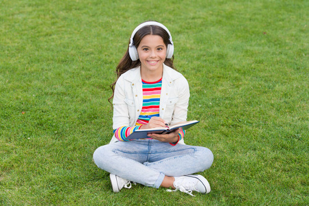 孩子们在绿草地上听音乐.健康的生活方式和放松.