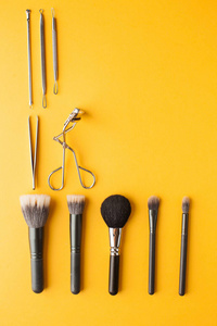  Professional makeup brushes top view on a yellow background wit