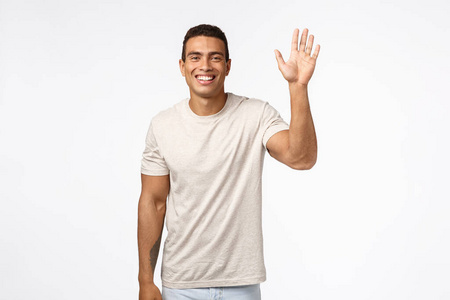 体恤友好开朗的体恤男子,举起一只手挥手打招呼,嗨,打招呼的手势,微笑