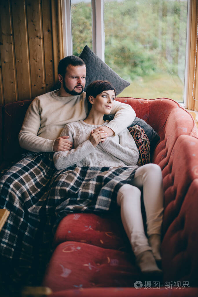 一对浪漫的情侣躺在家里的沙发上