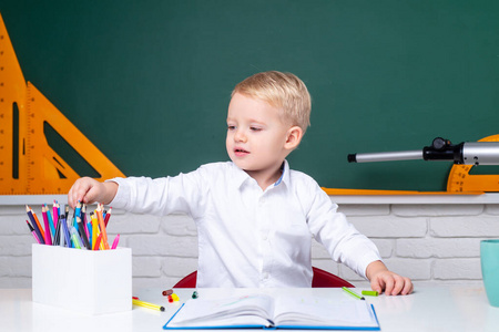 孩子准备上学。学童或学龄前儿童学习。可爱的小男孩在黑板桌旁边的教室里。