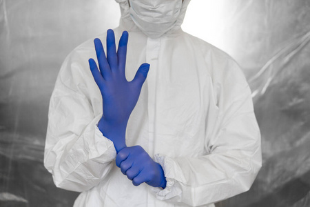 医生身着白色防护服,口罩,眼镜和橡胶手套,随时准备在冠状病毒大流行