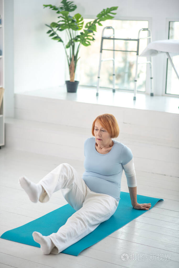 很好的活跃的老妇人抬起她的腿