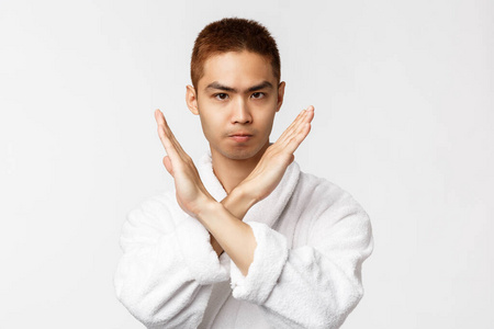 严肃自信的亚洲人双手交叉,皱着眉头,说不,不满意并给予强烈否认,禁止