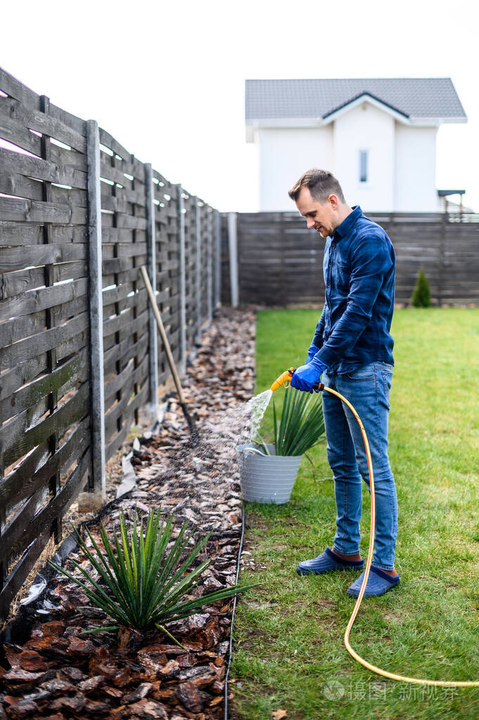 在后院浇花的年轻人