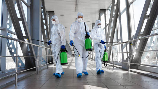 穿防护服戴口罩的人用毒气给隧道消毒照片