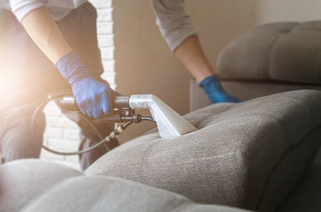 清理沙发男式干洗店员工手拿防护橡胶手套用专业的提取方法清洁沙发.