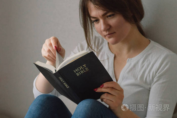 基督教女孩手里拿着圣经在客厅里读圣经信仰精神和宗教的概念