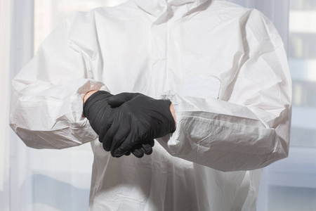 医生穿着个人防护装备,穿着制服,戴着手套,对双手进行消毒处理.