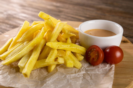 Fried potato with tomato sauce on paper, circle board and wooden