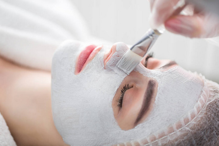 在水疗沙龙接受美容师的面部护理.照片