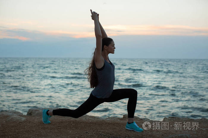 在海边练习瑜伽的高加索妇女。