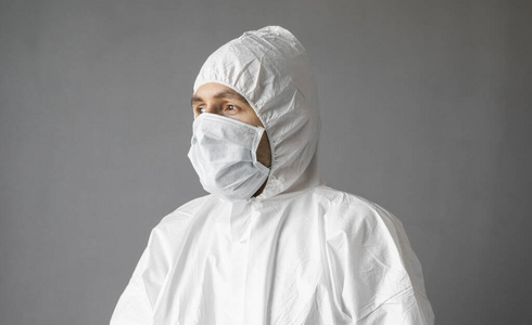 医生身着白色防护服,戴着医用口罩和橡胶手套,随时准备在冠状病毒大