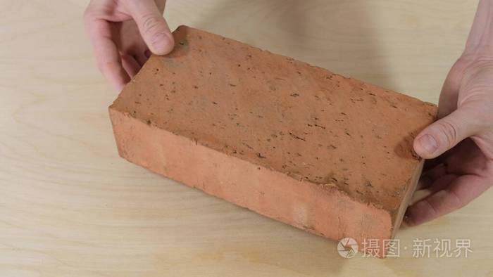 建筑工人手里拿着砖头闭合
