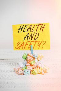 文字书写健康与安全。商业概念程序旨在防止工作场所事故提醒堆彩色皱褶纸衣夹提醒白色木质空间。