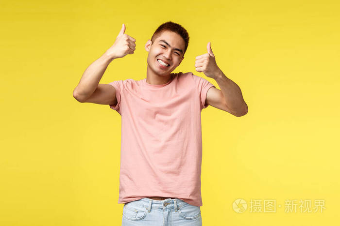 穿着粉色t恤的快乐亚洲男士对超赞的产品感到满意,竖起大拇指,笑容