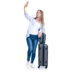 带着旅行箱的女士在智能手机上微笑自拍