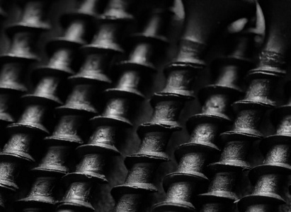 Black metal bolts on a black metal surface. Macro. Close up. 