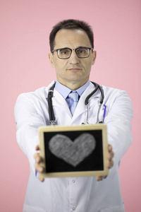 白人医生和听诊器在粉红色的背景白色外套持有心脏