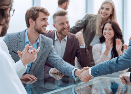 商务人士坐在办公桌前握手照片