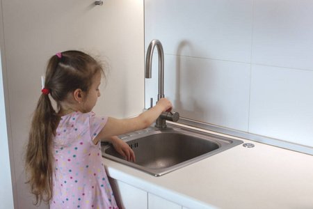 Little girl washing her hand. 