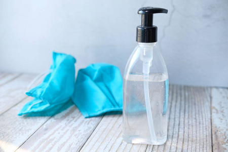 医用外科口罩和洗手液凝胶放在桌子上照片