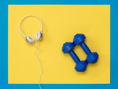蓝色哑铃和白色耳机，背景黄蓝相间。