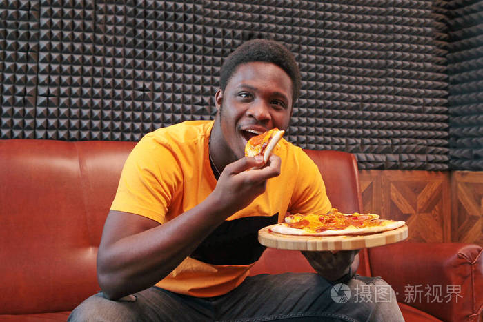 吃披萨的黑人年轻人内部照片空间的副本