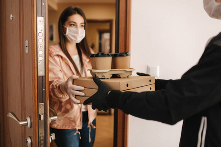 女人打开门点餐.冠状病毒主题照片