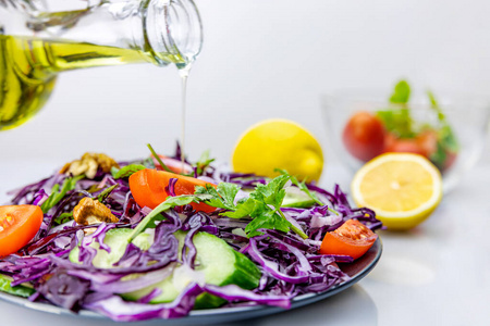 沙拉以蔬菜和香草为背景，浇上橄榄油，浅景深，选择性聚焦。健康饮食理念。