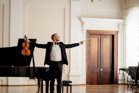 在舞台上演奏小提琴的专业音乐家照片