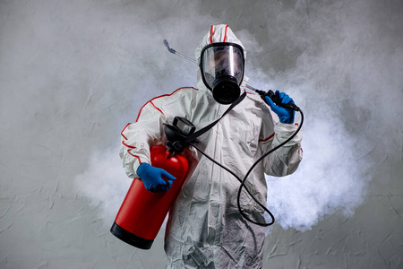身穿防毒服的男性对公共隔离空间进行消毒照片
